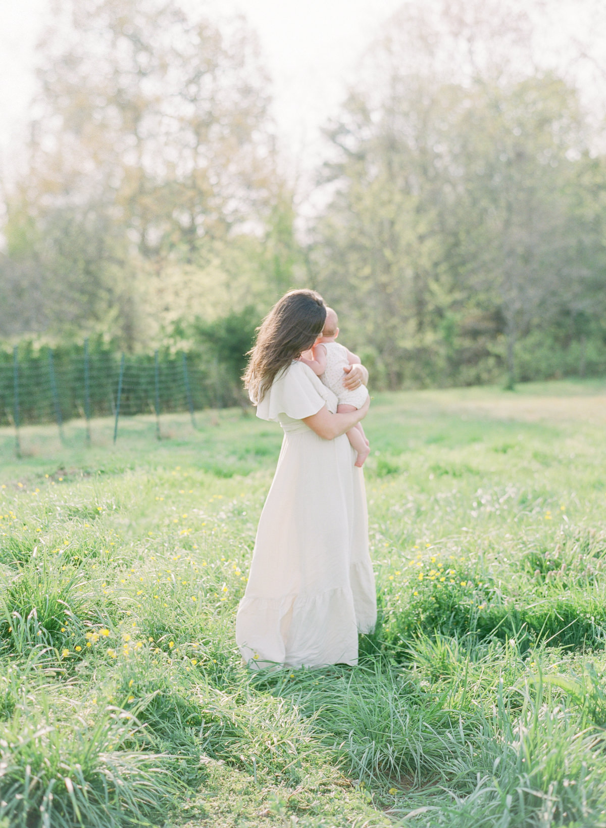 Kent-Avenue-Photography-Charlotte-Newborn-Photographers-On-Film-Mom-standing-holding-baby-in-field