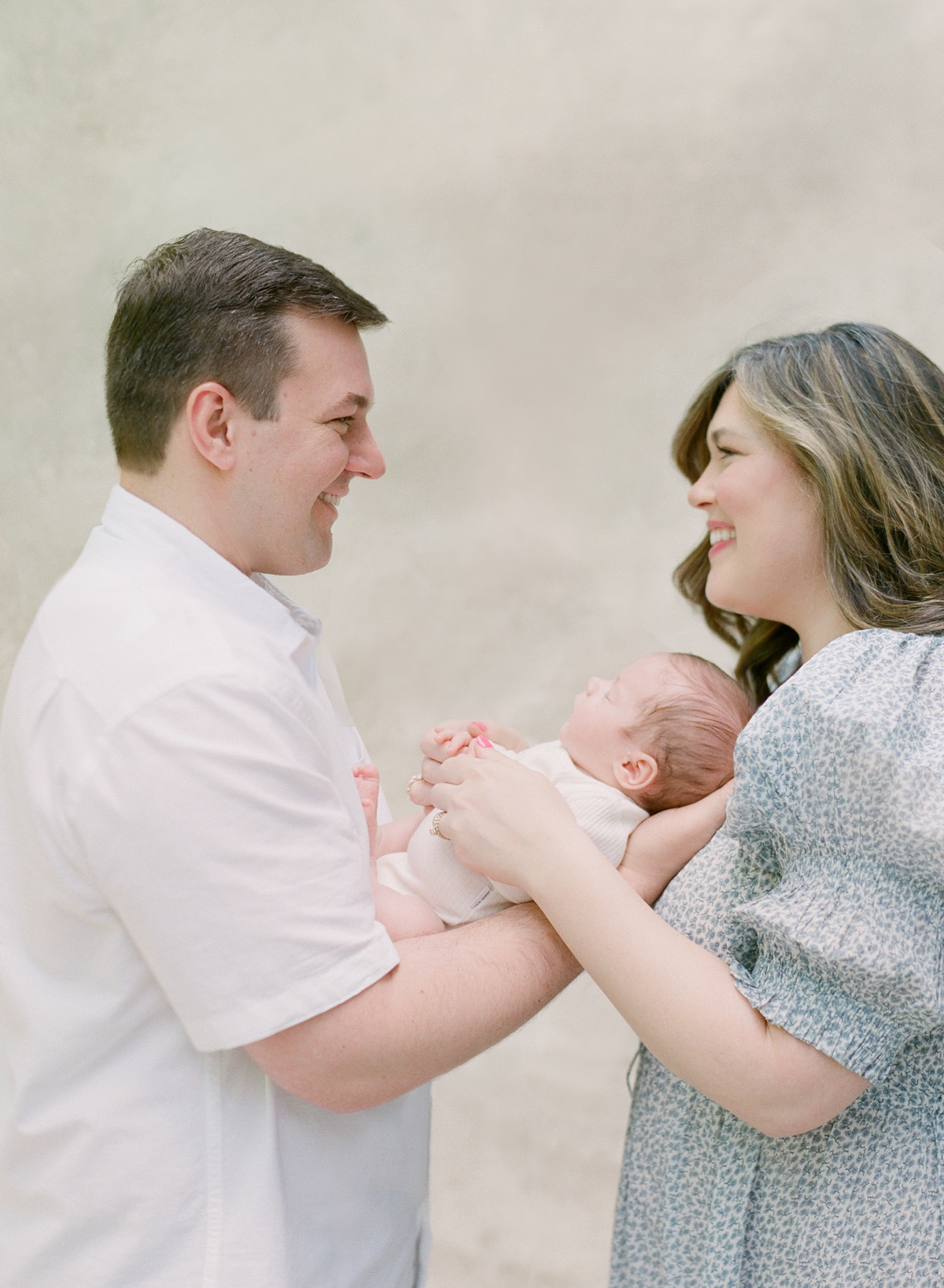 Top Charlotte Newborn Photographer - Mom and Dad Looking Down at Baby - Kent Avenue Photography