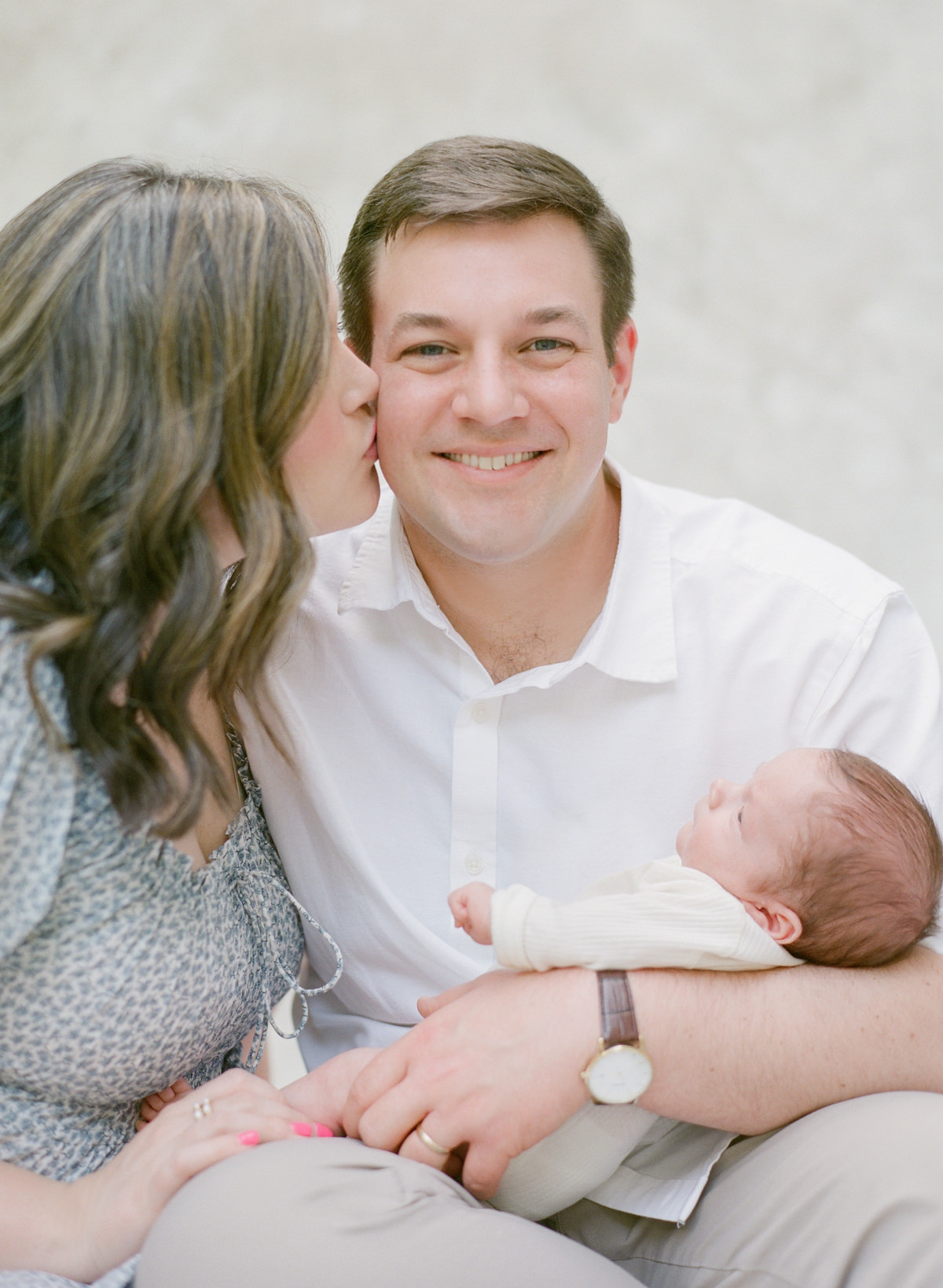 Charlotte Newborn Photographers - Mom Kissing Dad Holding Baby - Kent Avenue Photography