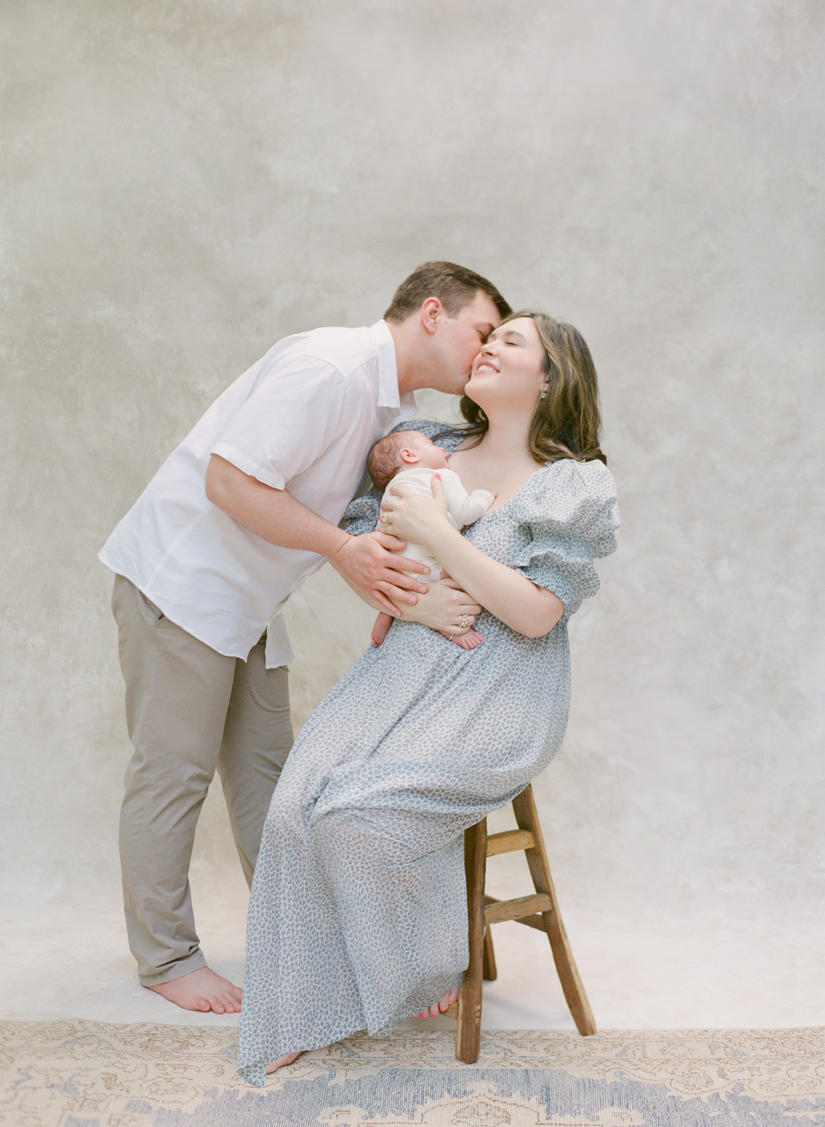 Charlotte Newborn Photography On Film - Mom and Dad Holding Baby And Kissing - Kent Avenue Photography